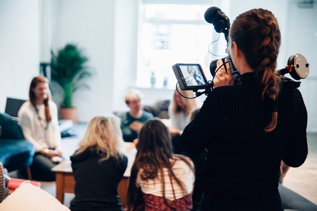 Photo by Vanilla Bear Films woman holding camera standing near people